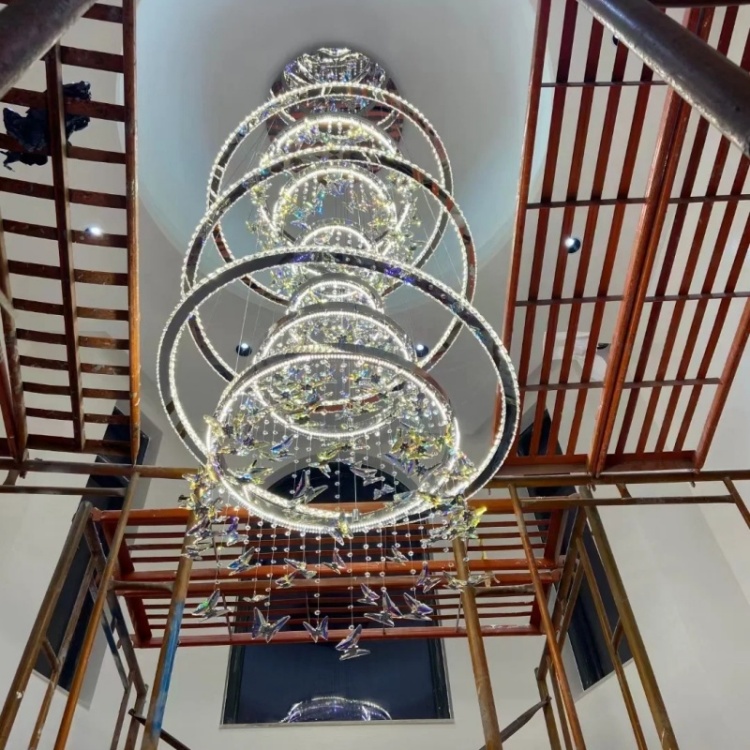 Stacked illuminated rings viewed upward through a tall stairwell